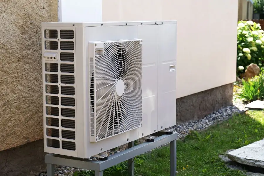 Outdoor air-source heat pump system installed beside a home, certified under the MCS scheme.