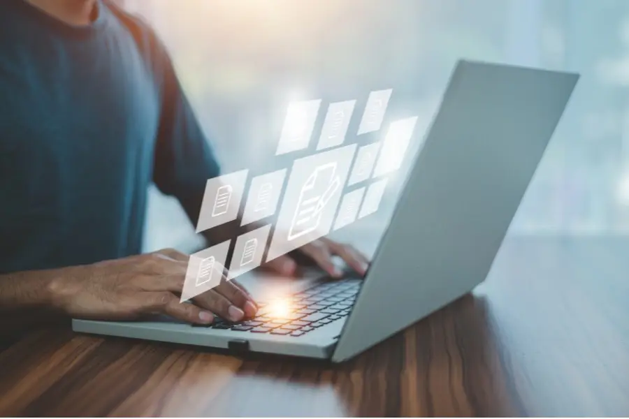 Laptop user accessing digital files representing ISO 9001 documentation and records management for quality management system compliance