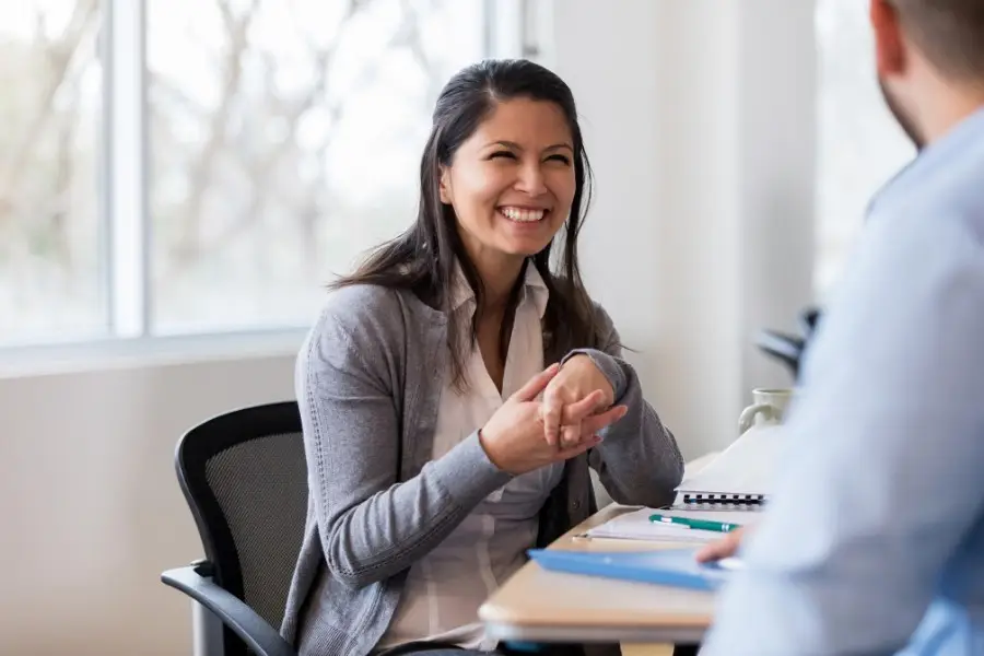 Smiling employee in a meeting, representing staff engagement and training as part of achieving ISO 9001 quality objectives.